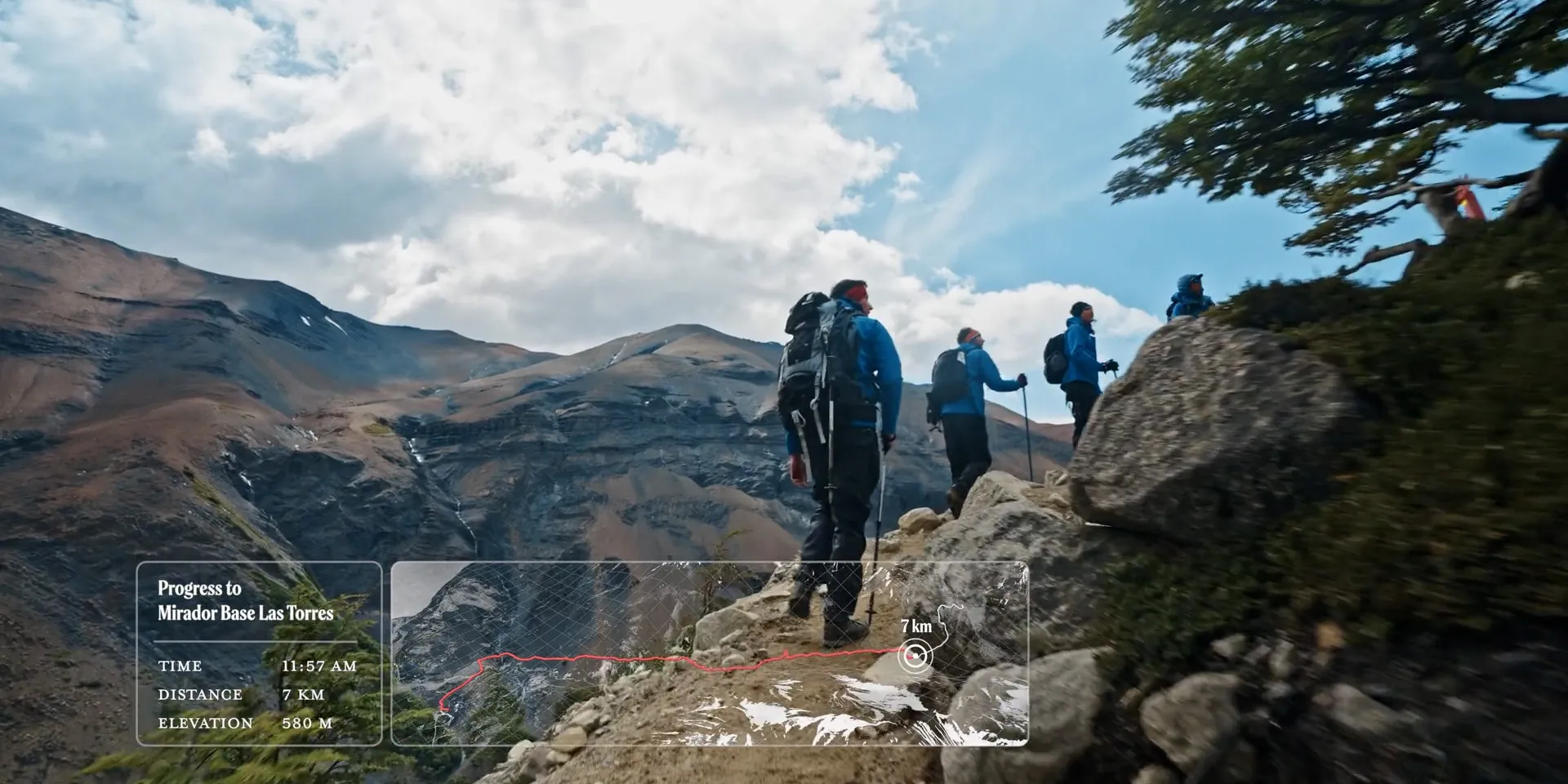 Hikers on a mountain trail with an overlay tracking progress to Mirador Base Las Torres: 7 km, 580 m elevation