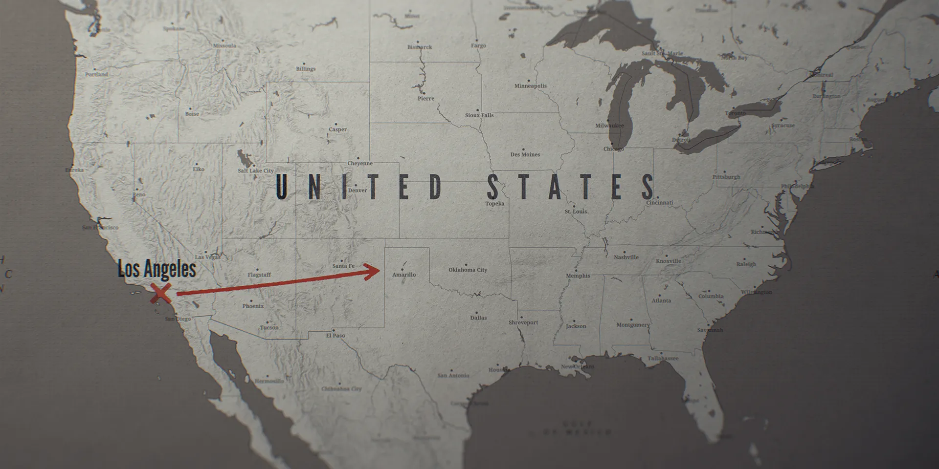 Relief map of the United States with Los Angeles marked by a red cross and an arrow running east