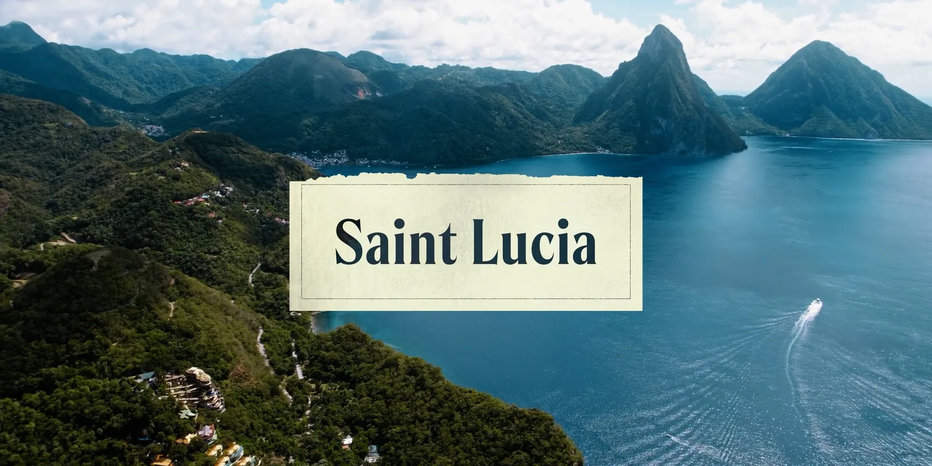 Aerial view of Saint Lucia’s Pitons over the bay, with a Saint Lucia location card